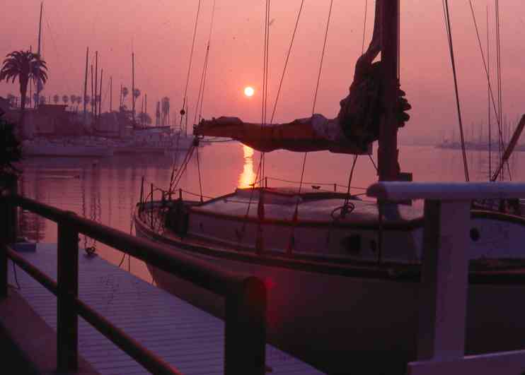 smoggy sunrise old sailboat in dock